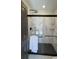 Modern bathroom shower featuring marble-look tile, rainfall shower head, and a sleek black door at 1038 Knotts Pointe Dr, Woodstock, GA 30188