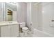 White bathroom featuring tiled shower/tub combo and a toilet adjacent to a vanity at 3605 Summit Gate Dr, Suwanee, GA 30024