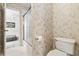 Cozy half-bathroom with gray marble wallpaper and toilet with an open door to the hallway at 3605 Summit Gate Dr, Suwanee, GA 30024