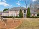 Elegant brick home featuring a well-manicured lawn, mature trees, and a symmetrical facade at 3605 Summit Gate Dr, Suwanee, GA 30024