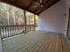 Relaxing back porch with wood ceiling, ceiling fan, wood decking and railing overlooking beautiful treed backyard at 136 Rainey Rd, Temple, GA 30179