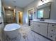 Bathroom showcasing marble floors, soaking tub, modern vanity and fixtures, and a tiled shower at 136 Rainey Rd, Temple, GA 30179