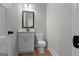 Bathroom with granite countertop, framed mirror, white toilet, and modern finishes at 136 Rainey Rd, Temple, GA 30179