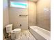 Bathroom with marble floors, neutral tiled shower, and white toilet for a modern design at 136 Rainey Rd, Temple, GA 30179