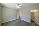 This bedroom offers carpeting, neutral walls, a ceiling fan and ample space at 136 Rainey Rd, Temple, GA 30179