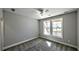 A well-lit bedroom with a ceiling fan, plush carpet, and a view from the double windows at 136 Rainey Rd, Temple, GA 30179