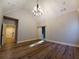 Spacious bedroom featuring high vaulted ceiling, wood flooring, modern lighting, and ensuite bathroom with sliding barn door at 136 Rainey Rd, Temple, GA 30179