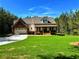 View of home's facade, featuring a well-manicured lawn, attached garage, and front porch at 136 Rainey Rd, Temple, GA 30179