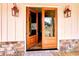 Charming front entrance features a wood door, stone accents, and decorative light fixtures at 136 Rainey Rd, Temple, GA 30179