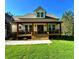Charming front exterior with inviting covered porch, stone accents, manicured lawn, and well-lit entryway at 136 Rainey Rd, Temple, GA 30179