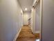 Hallway featuring wood-look floors, access to staircase, a closed door, and a sliding barn door at 136 Rainey Rd, Temple, GA 30179