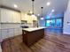 Bright kitchen boasts island, white cabinetry, stainless appliances and hardwood floors at 136 Rainey Rd, Temple, GA 30179