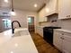 Kitchen with modern appliances, white cabinets, and a view of the pantry at 136 Rainey Rd, Temple, GA 30179