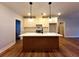 Island kitchen features a breakfast bar, white cabinetry, and modern fixtures at 136 Rainey Rd, Temple, GA 30179