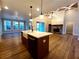 Bright kitchen featuring a center island with a farmhouse sink, stone fireplace, and hardwood flooring at 136 Rainey Rd, Temple, GA 30179