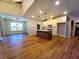 Island kitchen features white cabinetry, stainless steel appliances, and hardwood floors at 136 Rainey Rd, Temple, GA 30179