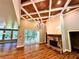 Open-concept living room boasts a stone fireplace, hardwood floors, and a wood-coffered ceiling at 136 Rainey Rd, Temple, GA 30179