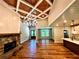 Spacious living room with a stone fireplace, wood-coffered ceiling, and an open layout to the kitchen at 136 Rainey Rd, Temple, GA 30179