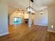 Living room featuring hardwood floors, a stone fireplace, a coffered ceiling, and access to the outdoor deck at 136 Rainey Rd, Temple, GA 30179