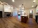 Open concept living area with a modern kitchen, stone fireplace, and hardwood floors at 136 Rainey Rd, Temple, GA 30179