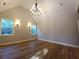 Charming main bedroom featuring stylish chandelier, sconces, and wood-look flooring at 136 Rainey Rd, Temple, GA 30179