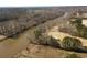 Scenic aerial view of a river flowing alongside a golf course with bare trees in the background at 2000 Stethem Ferry Rd, Johns Creek, GA 30022