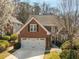 Charming brick home with a two-car garage and well-manicured landscaping and beautiful trees at 2000 Stethem Ferry Rd, Johns Creek, GA 30022