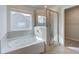 Bathroom featuring a tiled shower, and a garden tub for a soothing and bright space at 238 Arnewood Cir, Mcdonough, GA 30253