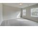 A spacious bedroom with two windows, carpet flooring, and neutral colors, ideal for relaxation at 238 Arnewood Cir, Mcdonough, GA 30253