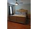 Bedroom features a large bed with blue curtains, ceiling fan and hardwood floors at 2760 Waterford Park Dr, Lawrenceville, GA 30044