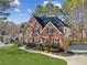 Elegant brick home features a well-maintained lawn, black shutters, and beautiful landscaping at 7115 Doncaster Ct, Cumming, GA 30040