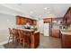 Basement kitchenette with wood cabinets, bar seating, stainless steel appliances, and tiled flooring at 7115 Doncaster Ct, Cumming, GA 30040