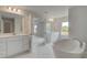 Open-concept bathroom featuring double vanities, a soaking tub and windows for natural light at 127 Felicity Pike, Locust Grove, GA 30248