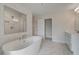 Bright bathroom featuring a soaking tub, walk-in shower with marble tile, and storage at 127 Felicity Pike, Locust Grove, GA 30248