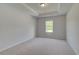 Bedroom featuring plush carpet, a tray ceiling, and a window at 127 Felicity Pike, Locust Grove, GA 30248