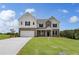 Charming two-story home with manicured front lawn, a two-car garage, and a combination brick and siding exterior at 127 Felicity Pike, Locust Grove, GA 30248