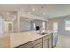 Modern kitchen with quartz countertop island overlooking spacious living area with fireplace at 127 Felicity Pike, Locust Grove, GA 30248