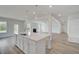 Bright kitchen features a large island with white cabinets and flows seamlessly into the living area at 127 Felicity Pike, Locust Grove, GA 30248