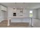 Modern kitchen featuring white cabinets, a spacious island, and sleek stainless-steel appliances at 127 Felicity Pike, Locust Grove, GA 30248