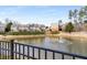 Scenic view of townhomes overlooking a tranquil pond with a fountain feature and manicured landscaping at 1741 Stanwood Dr, Kennesaw, GA 30152
