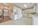 Bright kitchen with white cabinets, tiled flooring, and a view into the hallway at 5055 Hampton Bluff Ct, Roswell, GA 30075