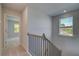 Hallway with stairway featuring modern black iron railings and natural light at 237 Chiswick Loop, Stockbridge, GA 30281