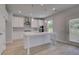Bright, open kitchen boasts white cabinets, an island with sink, stainless appliances, and a walk-in pantry at 237 Chiswick Loop, Stockbridge, GA 30281