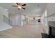 Open-concept living room with a fireplace, staircase, white kitchen, and luxury vinyl plank at 237 Chiswick Loop, Stockbridge, GA 30281