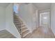A well-lit staircase featuring luxury vinyl plank flooring and a neutral paint at 237 Chiswick Loop, Stockbridge, GA 30281