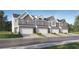 Charming townhome row featuring mixed brick and siding, attached garages, and well-manicured lawns at 2451 Livi Ln, Buford, GA 30519