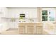 Bright kitchen with white cabinets, subway tile backsplash, and a breakfast bar for casual dining at 2451 Livi Ln, Buford, GA 30519