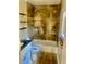 Bathroom featuring a tub and shower with warm toned stone-style tile and floating shelves at 5206 Westhill Nw Dr, Norcross, GA 30071