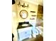 Bathroom with white vanity and black countertop, round mirror, and modern vanity lights at 5206 Westhill Nw Dr, Norcross, GA 30071
