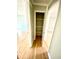Hallway leading to rooms with a door to a shelved closet with storage at 5206 Westhill Nw Dr, Norcross, GA 30071